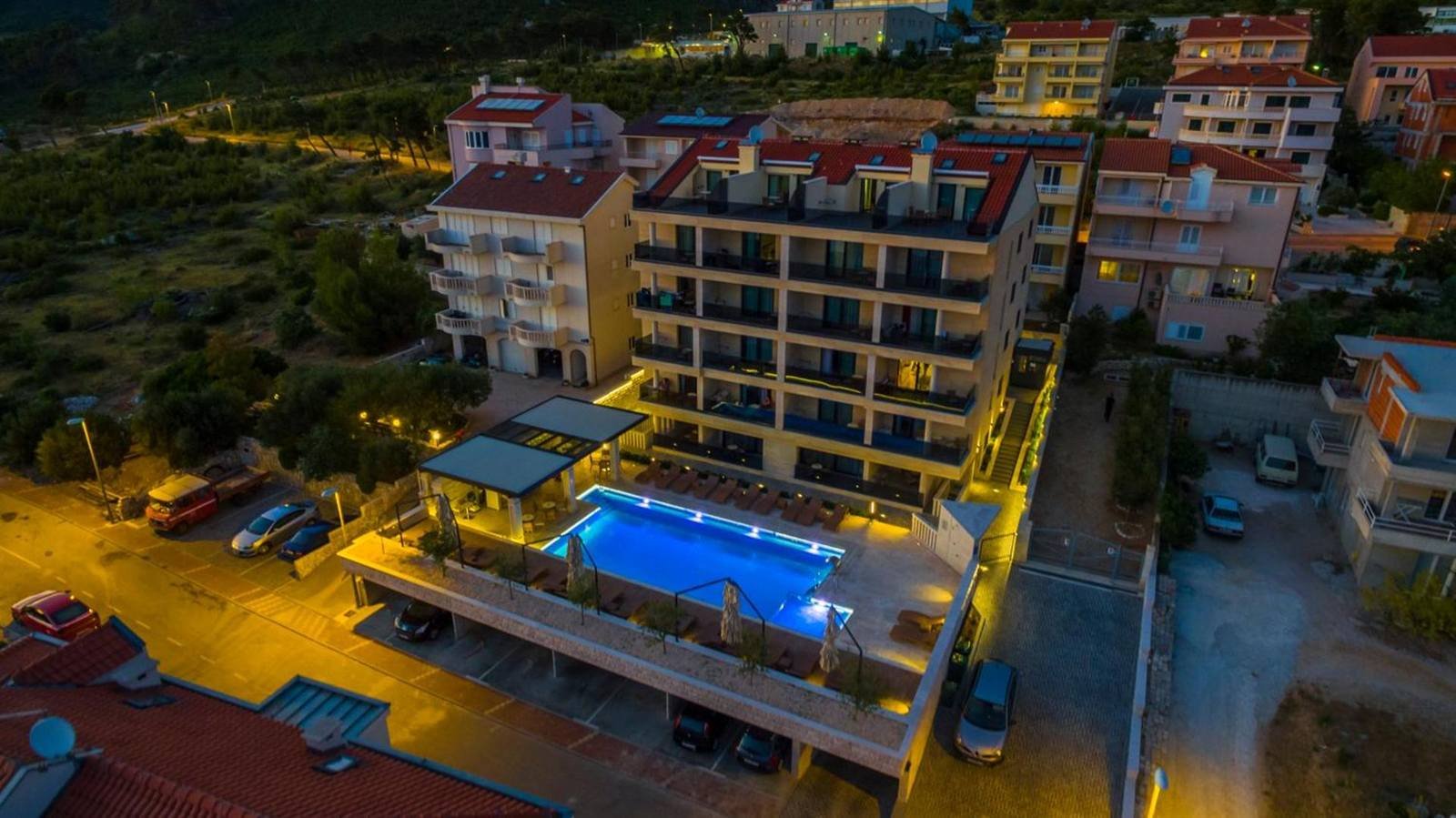 Luxury Aparthotel: aerial view of the building and the pool lit up at night