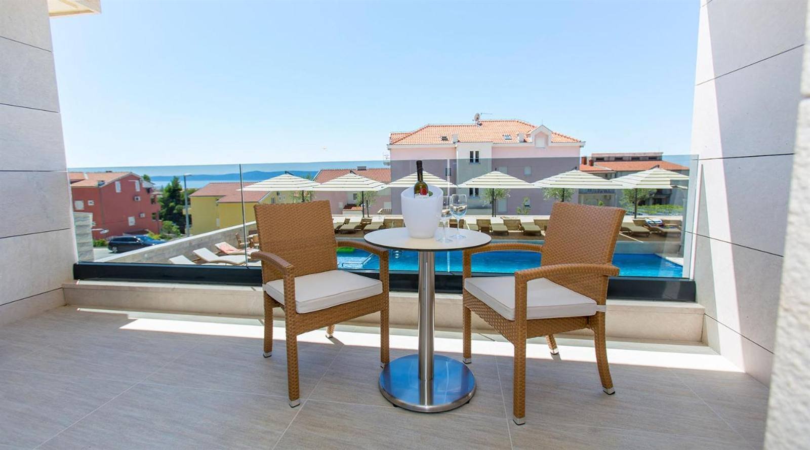 Luxury Aparthotel: balcony with table and chairs overlooking the pool and the sea