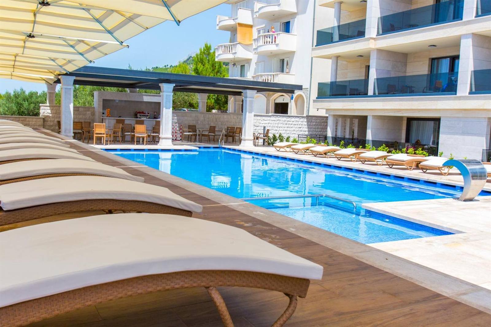 Luxury Aparthotel: pool terrace with loungers and umbrellas by day